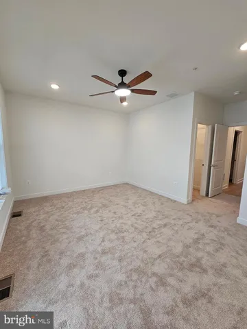 an empty room with closet and ceiling fan