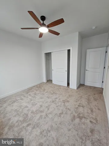 a view of a hallway with wooden floor and closet