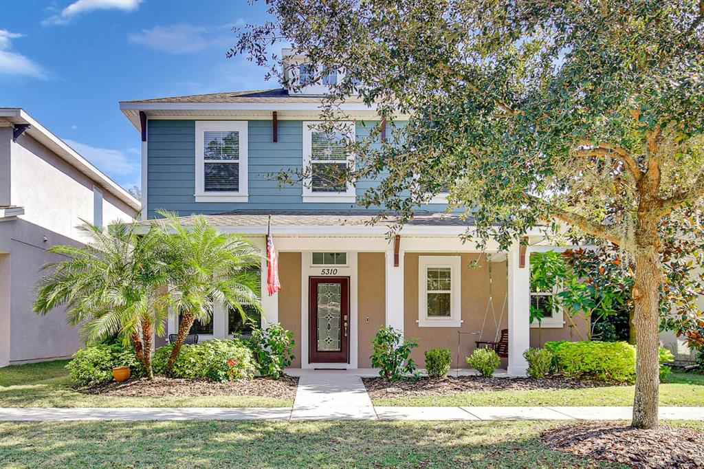 a front view of a house with a yard and potted plants
