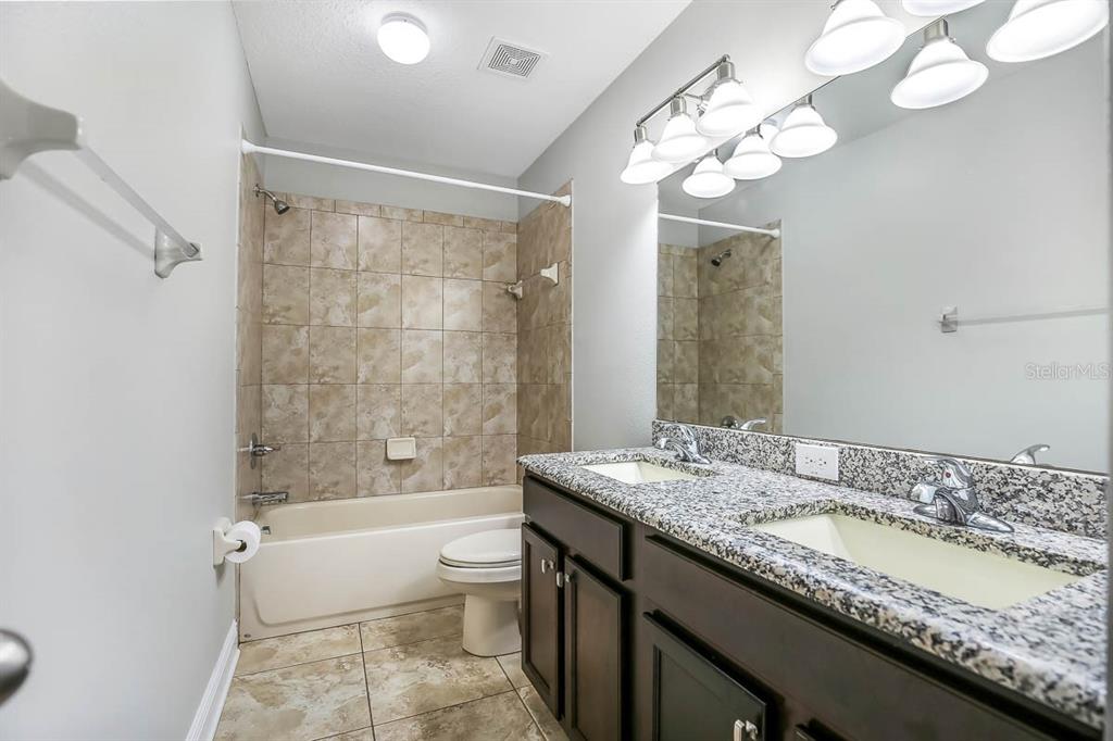 5310 Match Point Place Lithia, FL 33547 - Photo 15 of 33 a bathroom with a granite countertop bathtub a sink and a large mirror