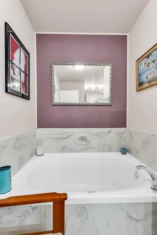 a bathroom with a bathtub and mirror