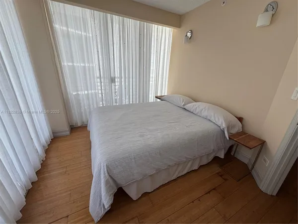 a bed sitting in a bedroom next to a window