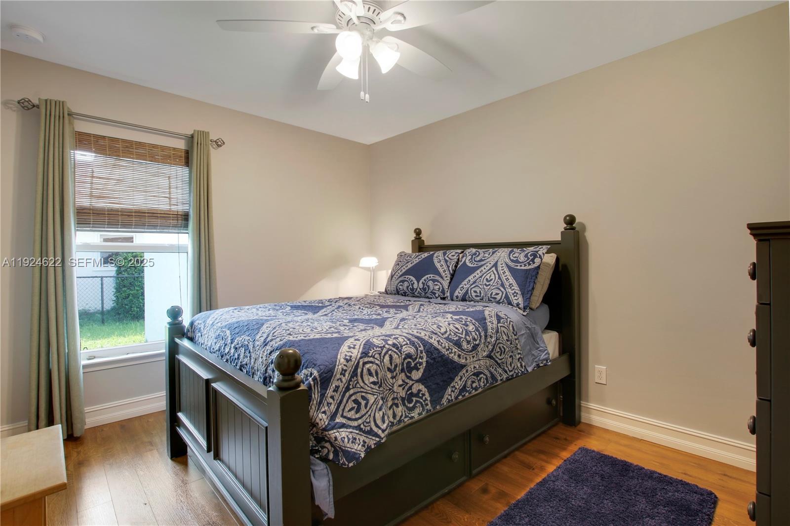 9155 Southeast Athena Street Hobe Sound, FL 33455 - Photo 11 of 25 a bedroom with a bed and a chandelier