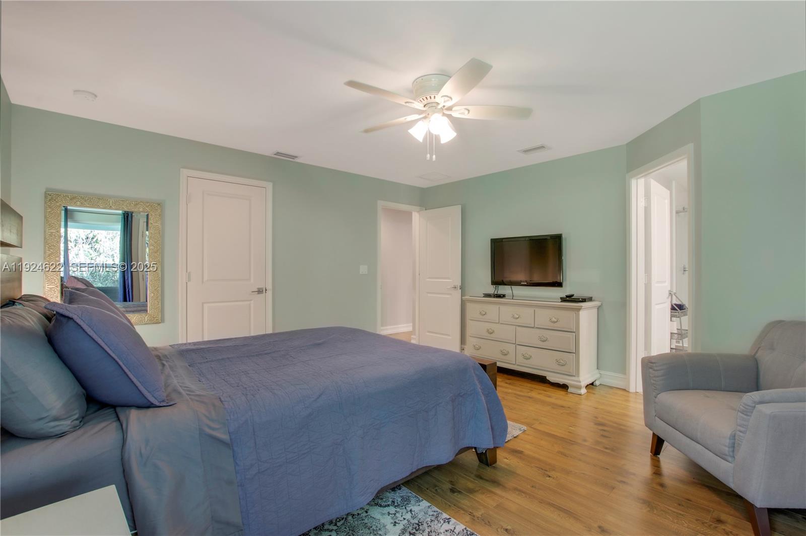 9155 Southeast Athena Street Hobe Sound, FL 33455 - Photo 15 of 25 a bedroom with a bed and a flat screen tv