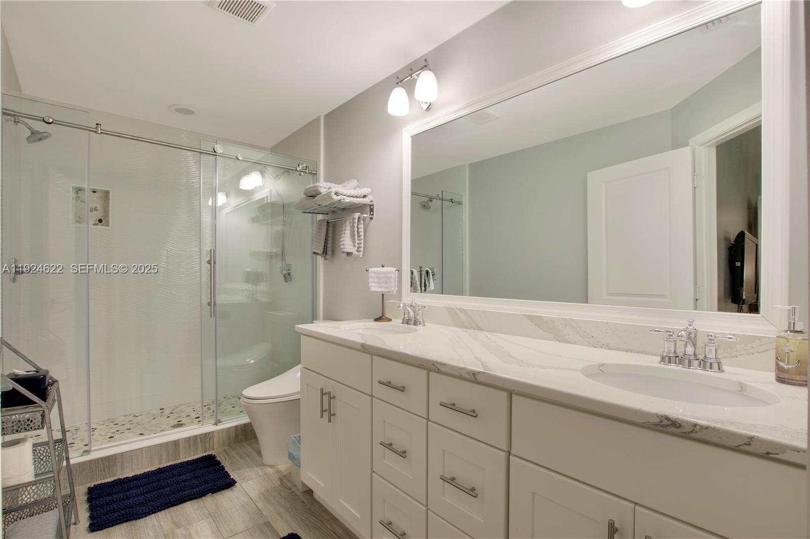 9155 Southeast Athena Street Hobe Sound, FL 33455 - Photo 16 of 25 a bathroom with a granite countertop sink toilet and shower