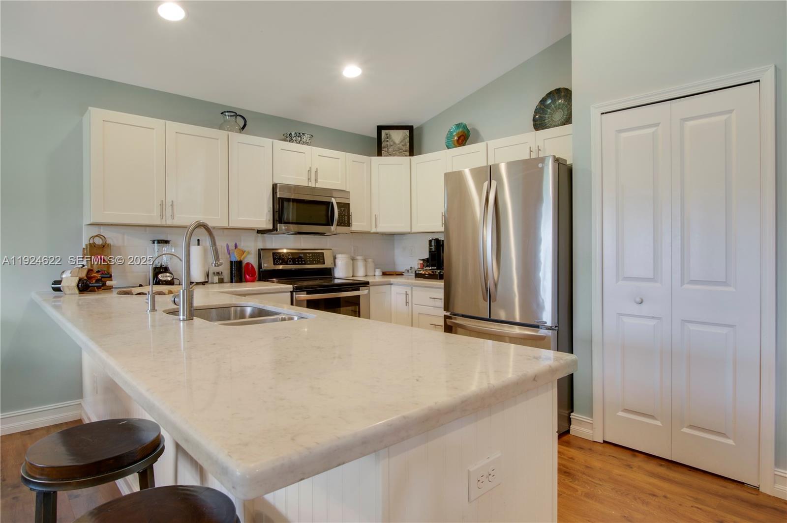 9155 Southeast Athena Street Hobe Sound, FL 33455 - Photo 9 of 25 a kitchen with stainless steel appliances a refrigerator stove microwave and sink