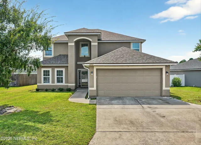 a front view of a house with a yard and garage