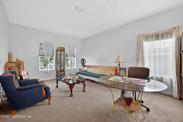 a living room with furniture a flat screen tv and gym equipment