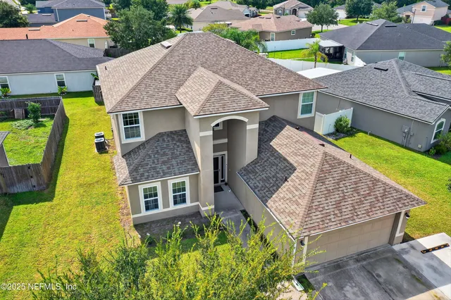 a view of a house with backyard and trees