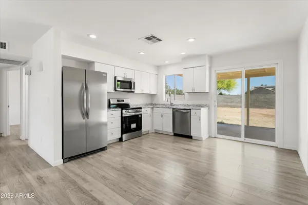 a kitchen with stainless steel appliances granite countertop a refrigerator and a stove top oven
