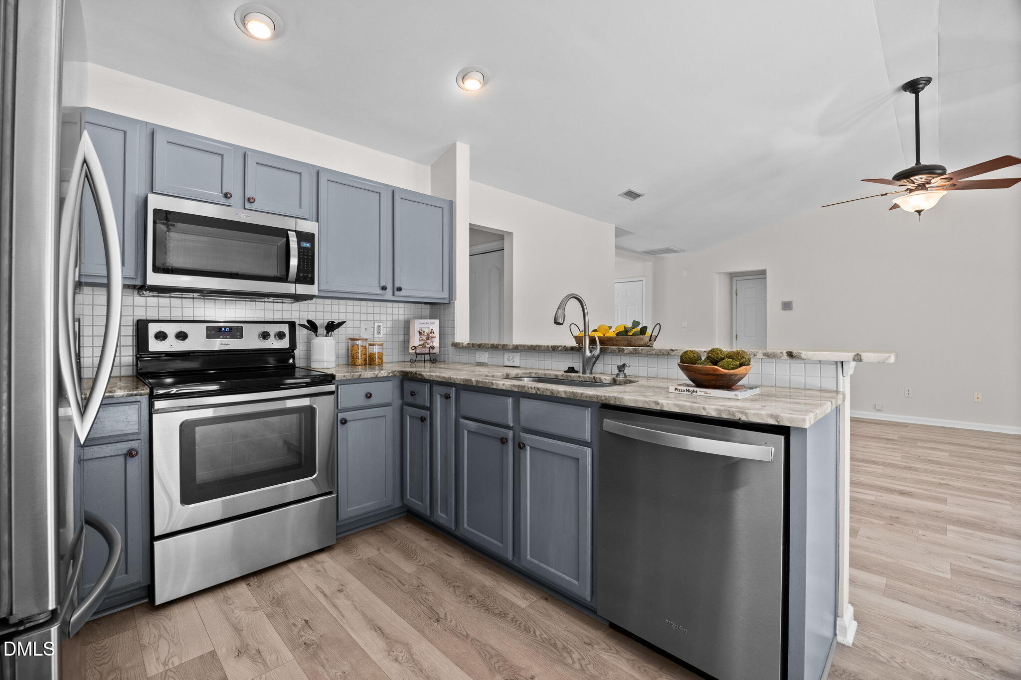 104 Saddle River Road Apex, NC 27502 - Photo 11 of 42 a kitchen with granite countertop a sink stainless steel appliances and cabinets