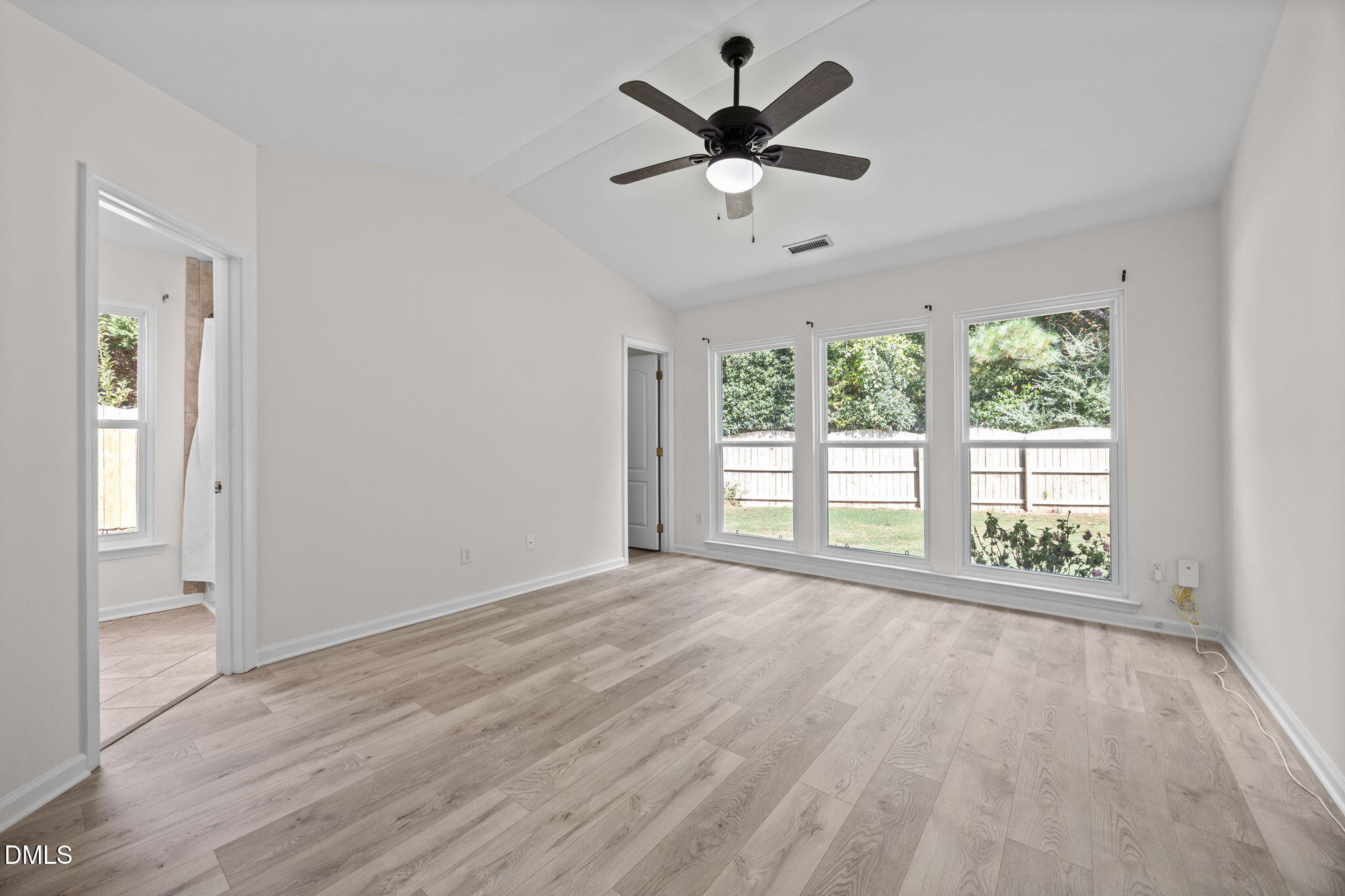 104 Saddle River Road Apex, NC 27502 - Photo 13 of 42 an empty room with wooden floor fan and windows