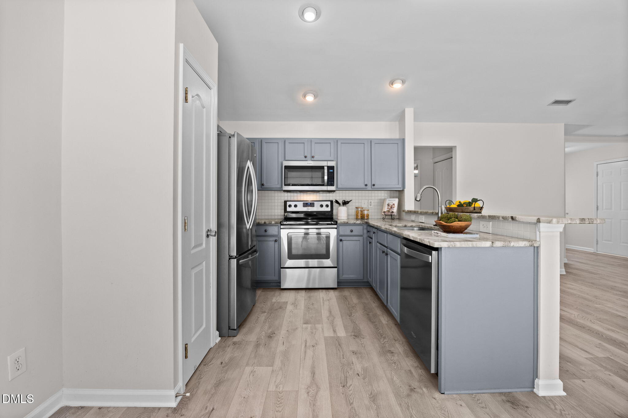 104 Saddle River Road Apex, NC 27502 - Photo 10 of 42 a kitchen with stainless steel appliances granite countertop a stove a sink and a refrigerator