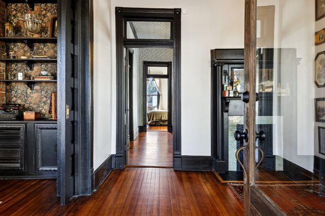 a view of a hallway with wooden floor and closet