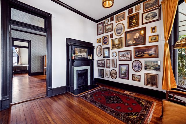 a view of a hallway with wooden floor and a book shelf