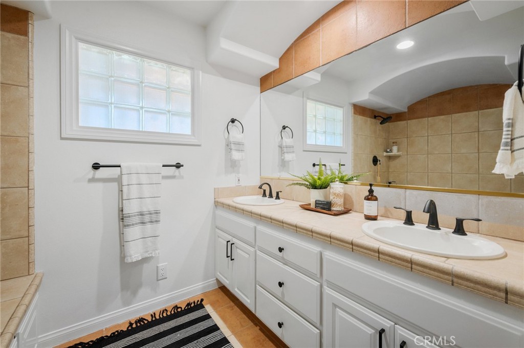 101 Esplanade San Clemente, CA 92672 - Photo 23 of 39 a bathroom with a double vanity sink a mirror and a shower
