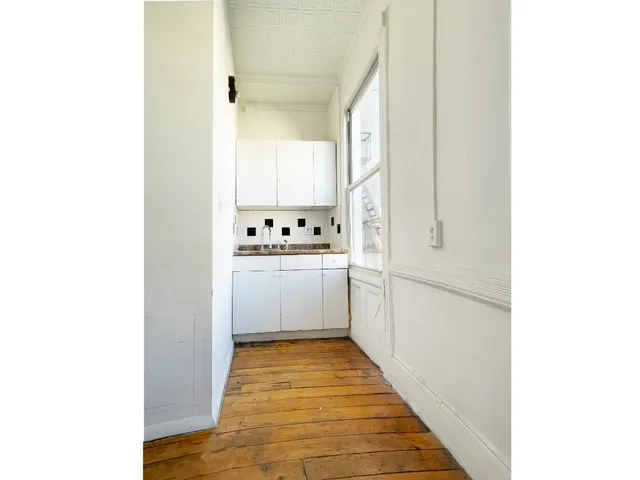 a view of a hallway with wooden floor and entryway