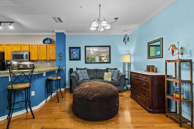 a living room with furniture kitchen view and a window