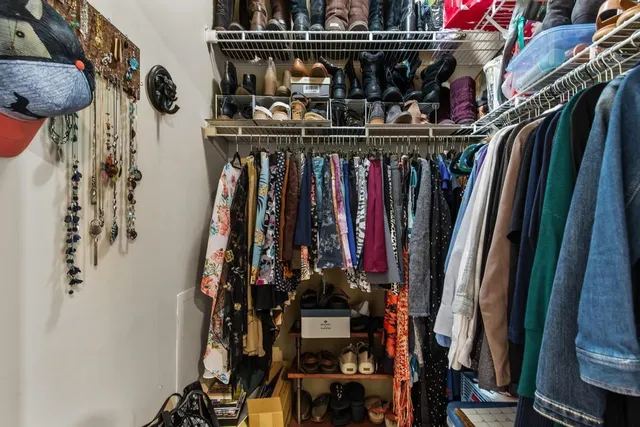 a view of walk in closet with clothes and shoes