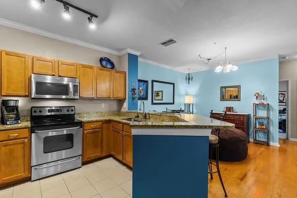 a kitchen with stainless steel appliances granite countertop a stove a sink dishwasher a microwave oven with granite countertops and cabinets