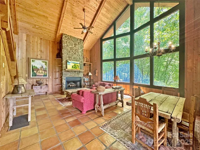 a living room with fireplace furniture and floor to ceiling windows