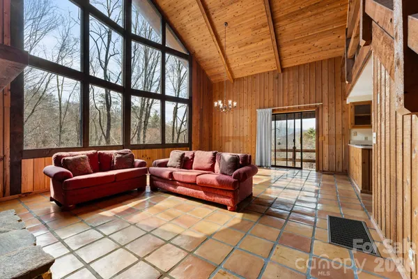 an empty room with windows and ceiling fan