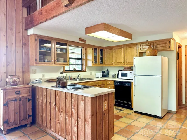 a kitchen with a sink a refrigerator and cabinets