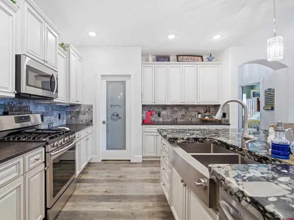 a kitchen with stainless steel appliances granite countertop a stove a sink and a microwave
