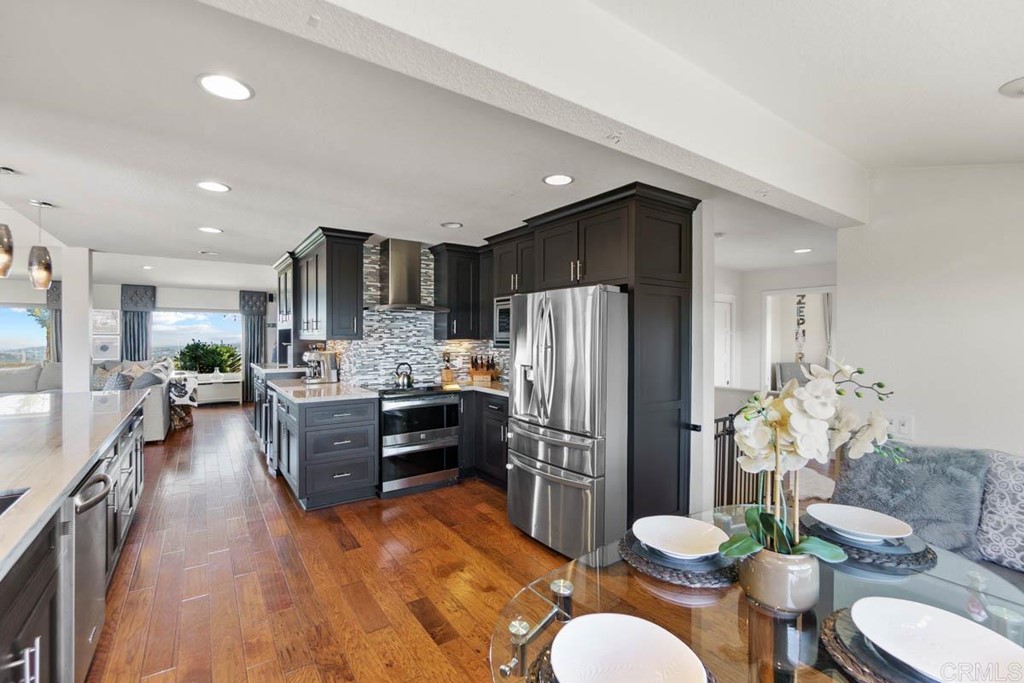 777 Phoenix Way San Marcos, CA 92078 - Photo 13 of 75 a kitchen with stainless steel appliances granite countertop a refrigerator a sink dishwasher a dining table and chairs with wooden floor
