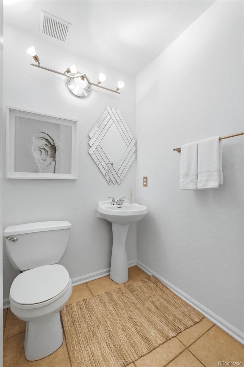 3033 East 108th Drive Northglenn, CO 80233 - Photo 14 of 50 a bathroom with a sink a toilet and mirror