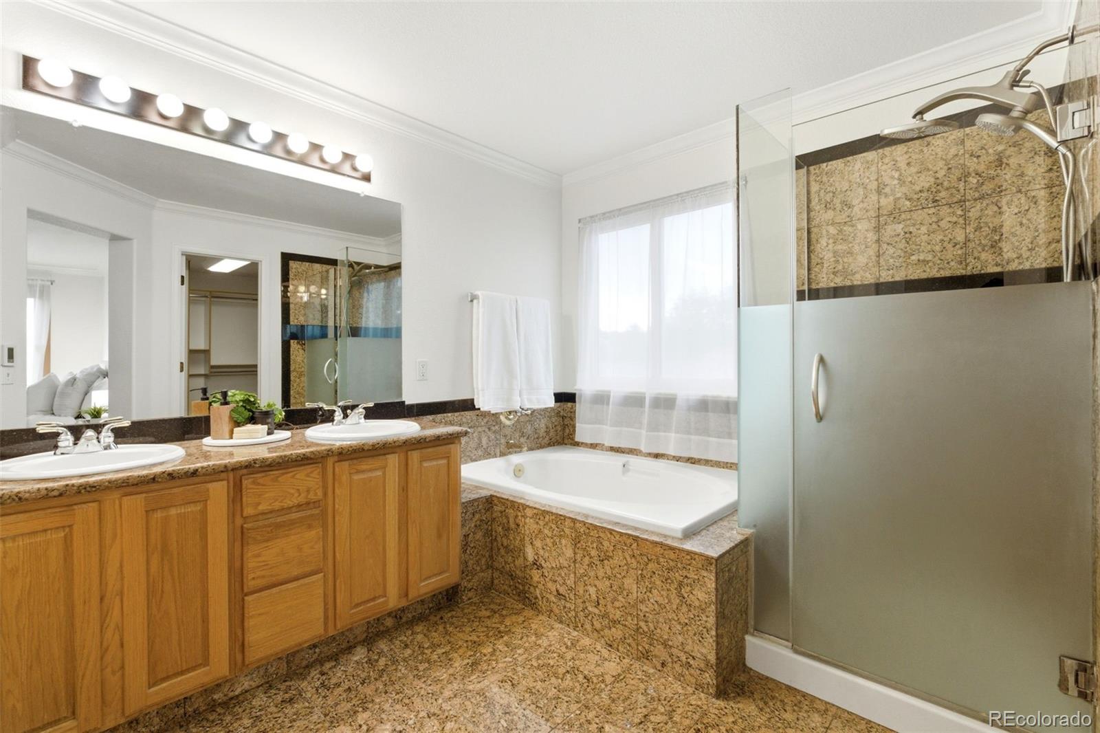 3033 East 108th Drive Northglenn, CO 80233 - Photo 21 of 50 a bathroom with a tub a sink and a mirror