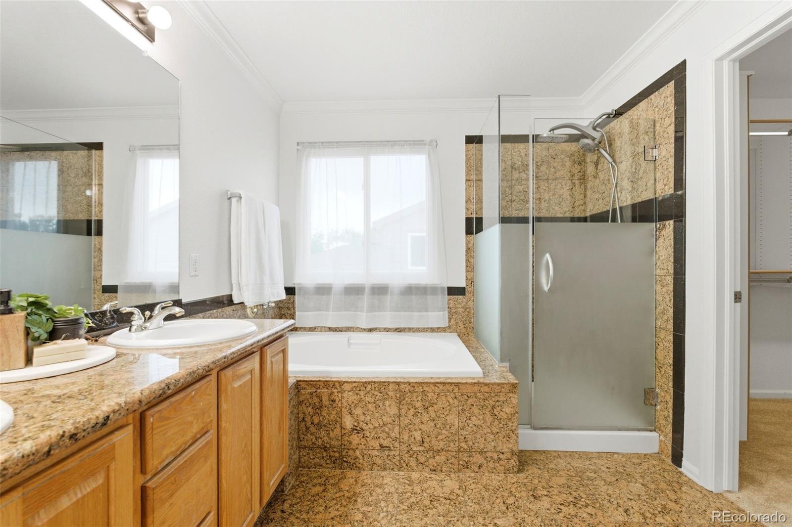 3033 East 108th Drive Northglenn, CO 80233 - Photo 22 of 50 a bathroom with a granite countertop sink mirror and shower