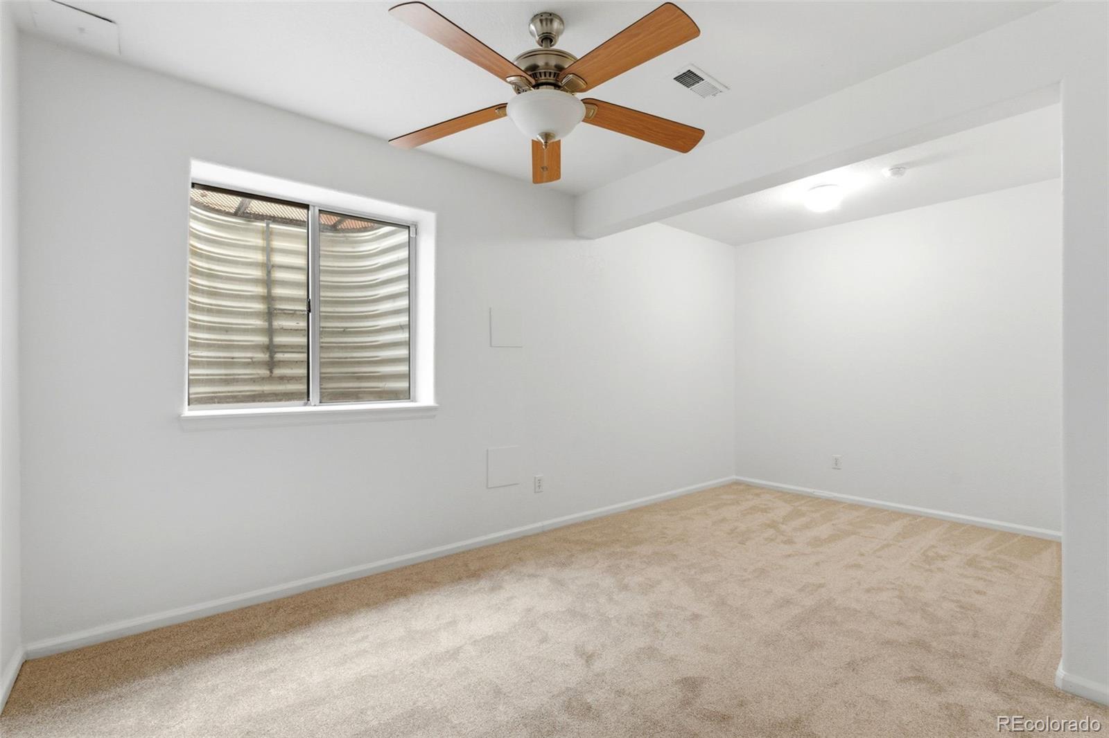3033 East 108th Drive Northglenn, CO 80233 - Photo 33 of 50 an empty room with a window and a ceiling fan
