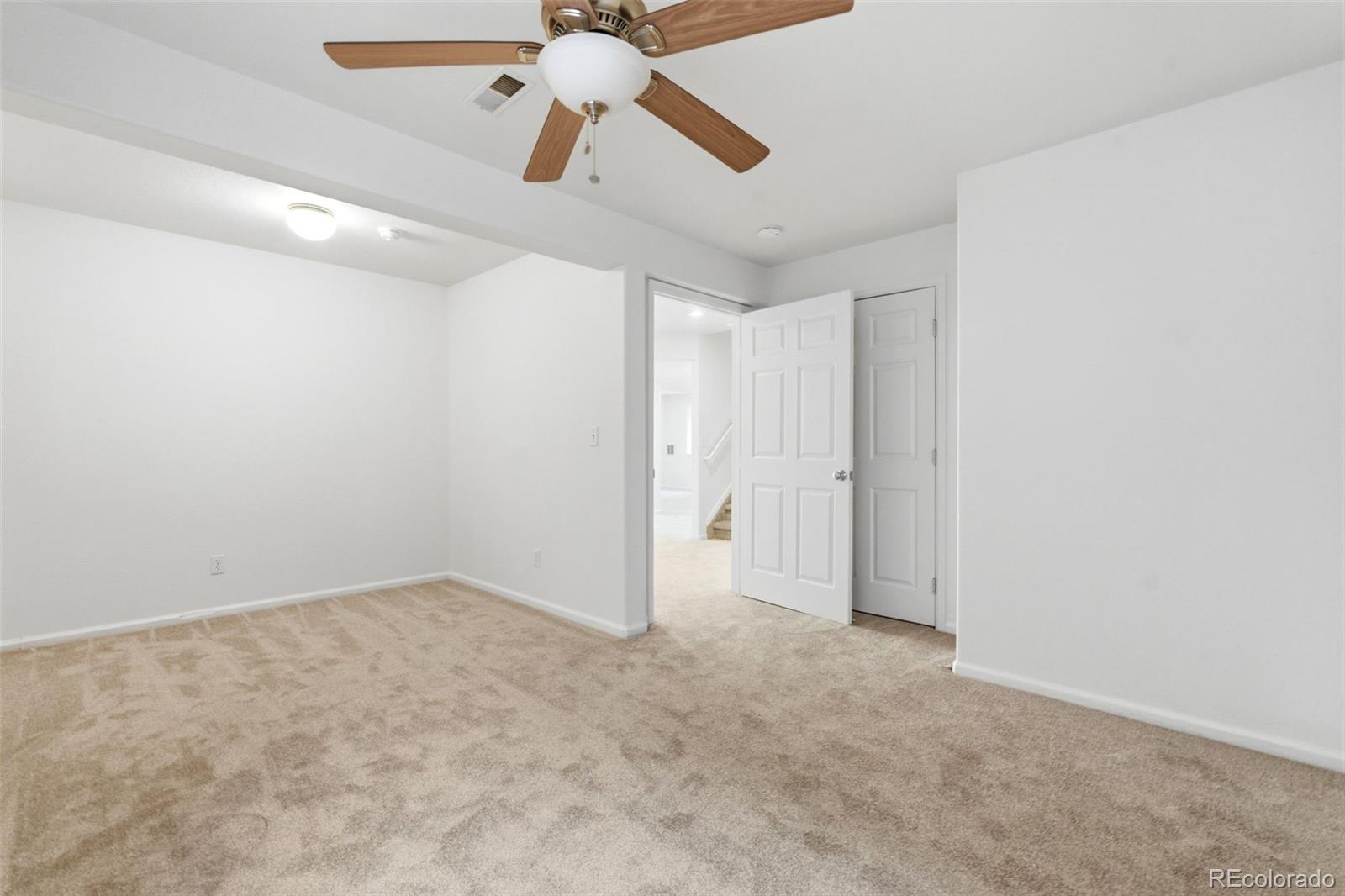 3033 East 108th Drive Northglenn, CO 80233 - Photo 34 of 50 an empty room with chandelier fan