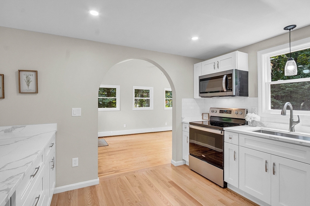 100 Dunstable Road North Chelmsford, MA 01863 - Photo 6 of 30 a kitchen with stainless steel appliances granite countertop a stove top oven a sink dishwasher a microwave oven with cabinets and wooden floor