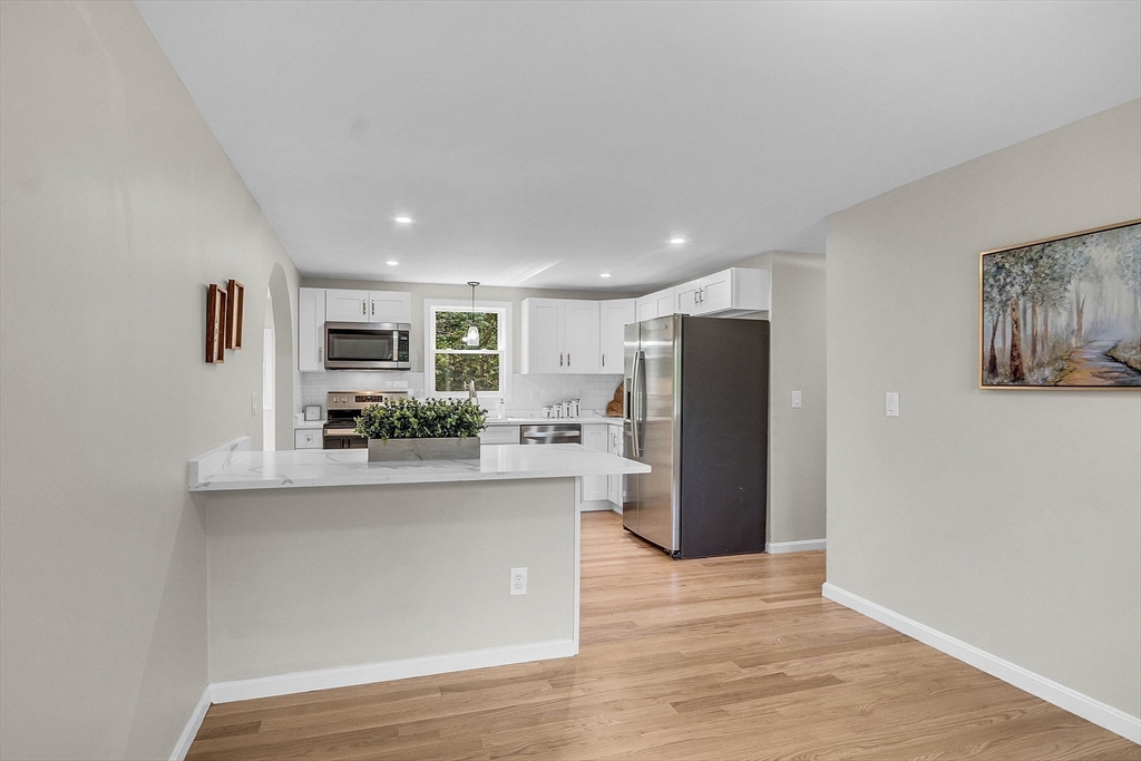 100 Dunstable Road North Chelmsford, MA 01863 - Photo 8 of 30 a living room with stainless steel appliances kitchen island granite countertop a refrigerator and a stove top oven