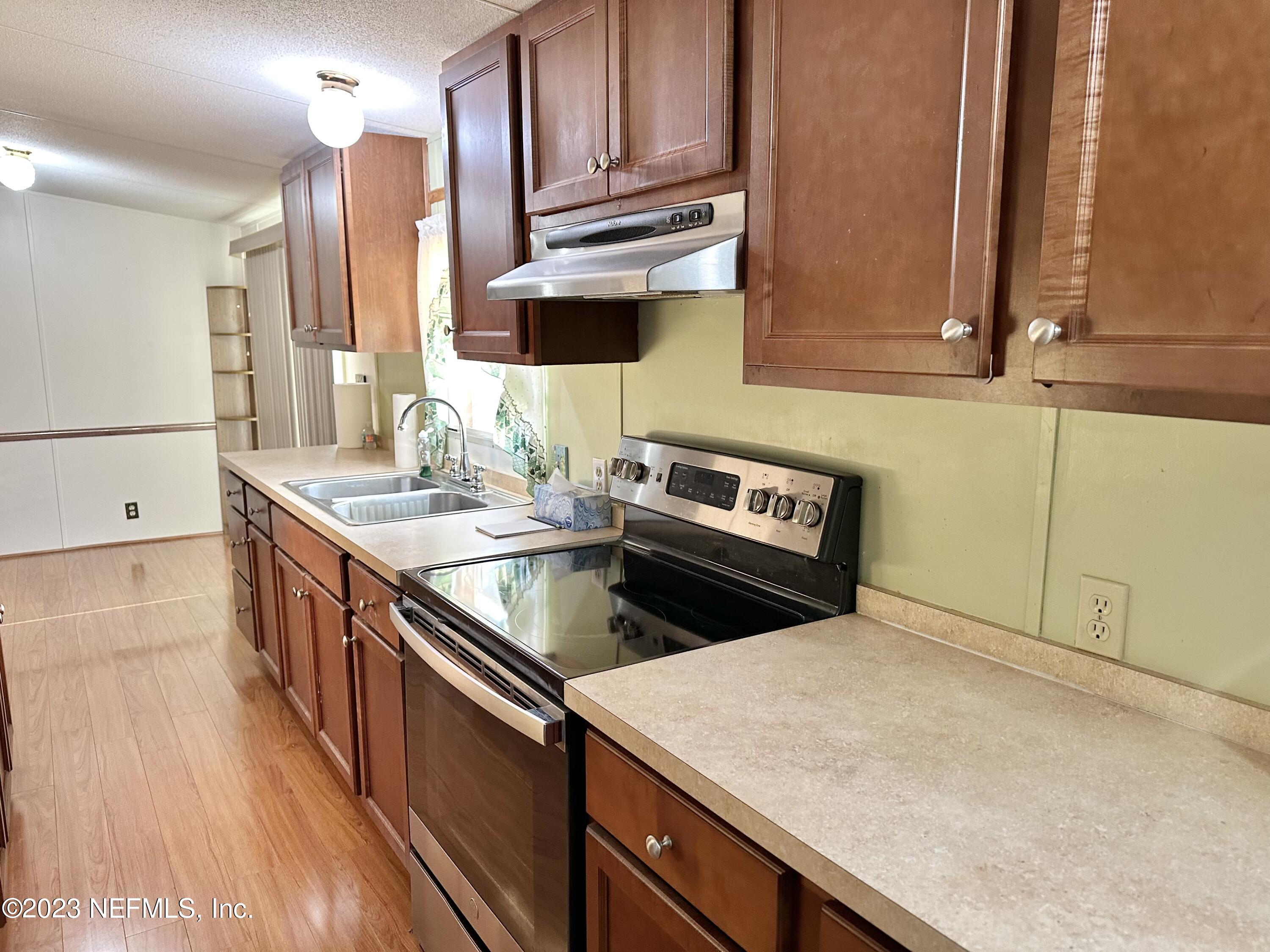 15644 Sears Road Jacksonville, FL 32218 - Photo 11 of 24 a kitchen with stainless steel appliances granite countertop a sink a stove and a microwave oven