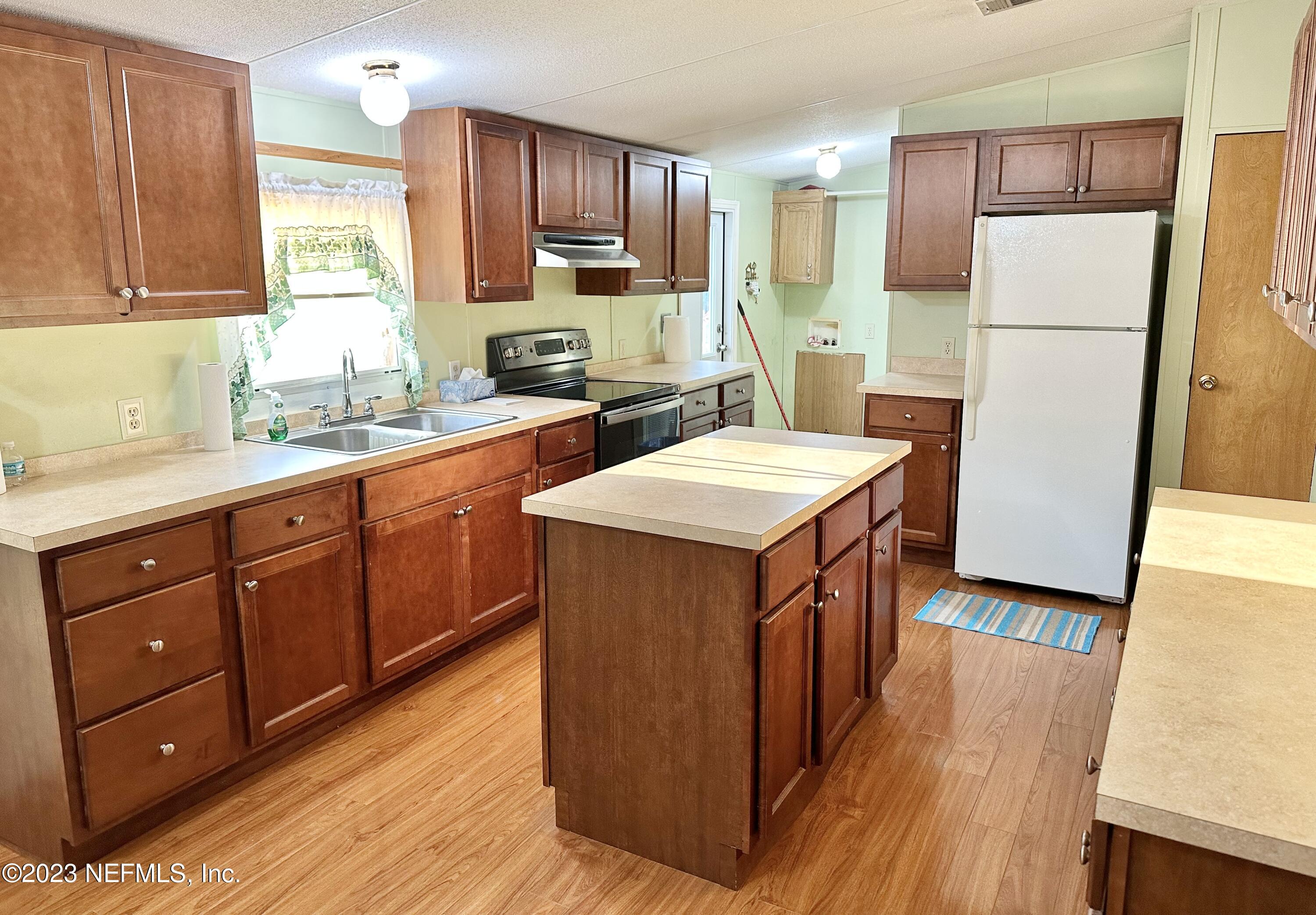 15644 Sears Road Jacksonville, FL 32218 - Photo 9 of 24 a kitchen with stainless steel appliances granite countertop a refrigerator a sink a stove a microwave and wooden floors
