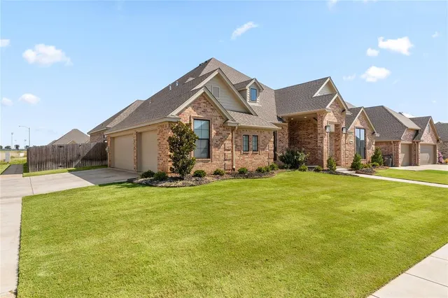 a view of a house with a big yard and potted plants