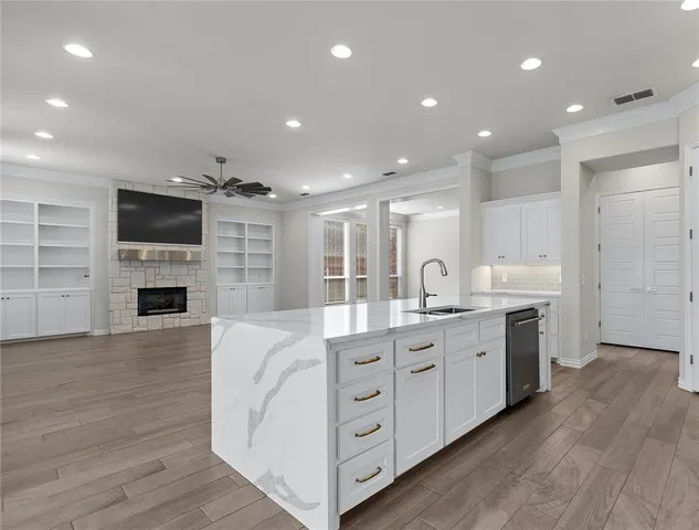 a large kitchen with stainless steel appliances granite countertop a stove and a wooden floors