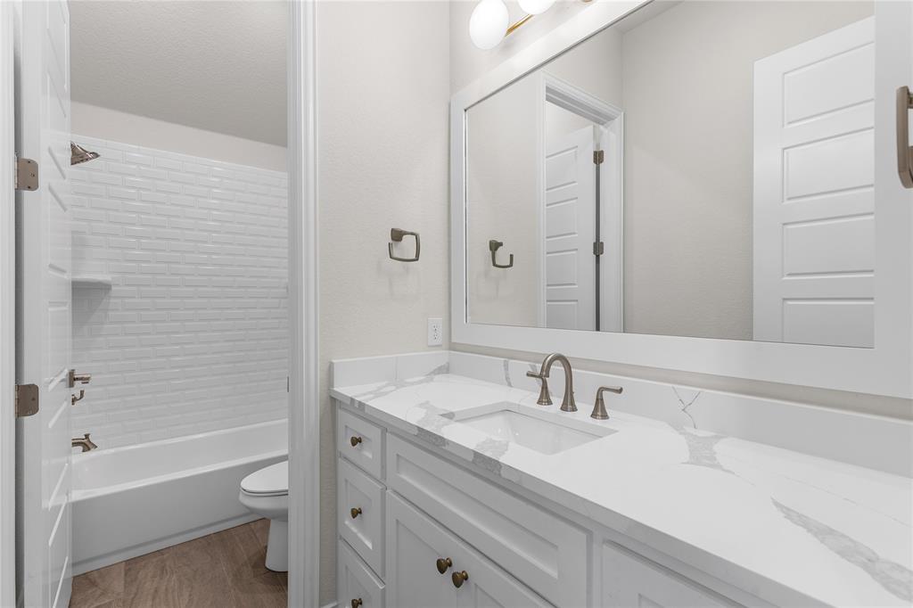 5682 Blackstone Drive Wichita Falls, TX 76310 - Photo 22 of 31 a bathroom with a granite countertop sink a toilet and shower