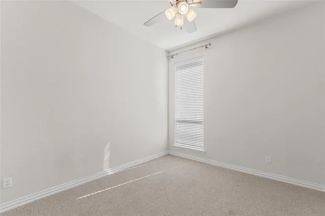 an empty room with a chandelier fan