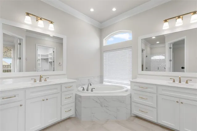 a bathroom with double vanity sink a mirror and a bathtub