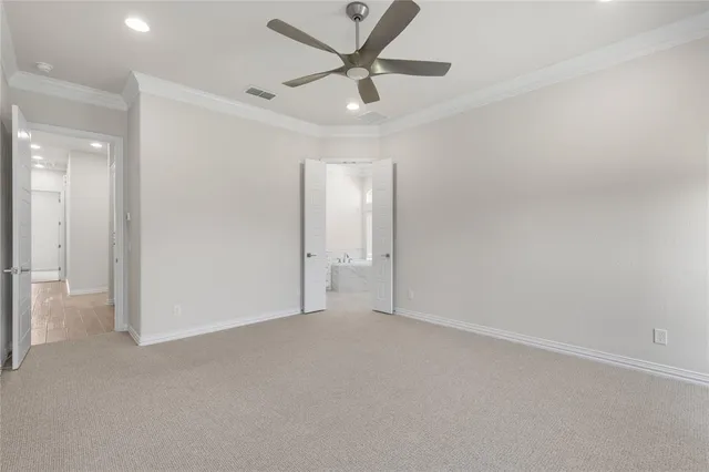 an empty room with closet and a ceiling fan