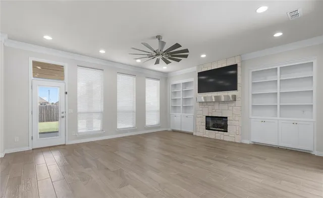 a view of an empty room with a fireplace and a window