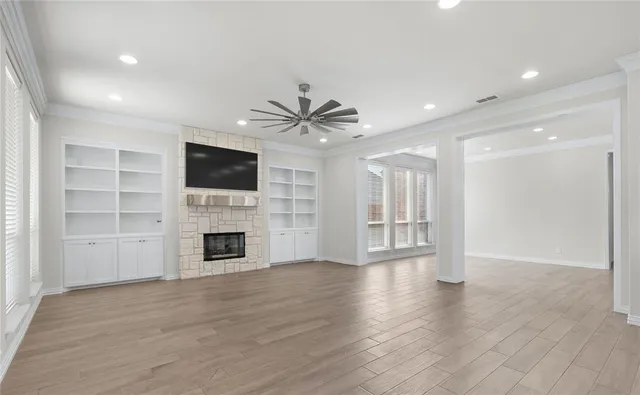 a view of an empty room with a fireplace and a window