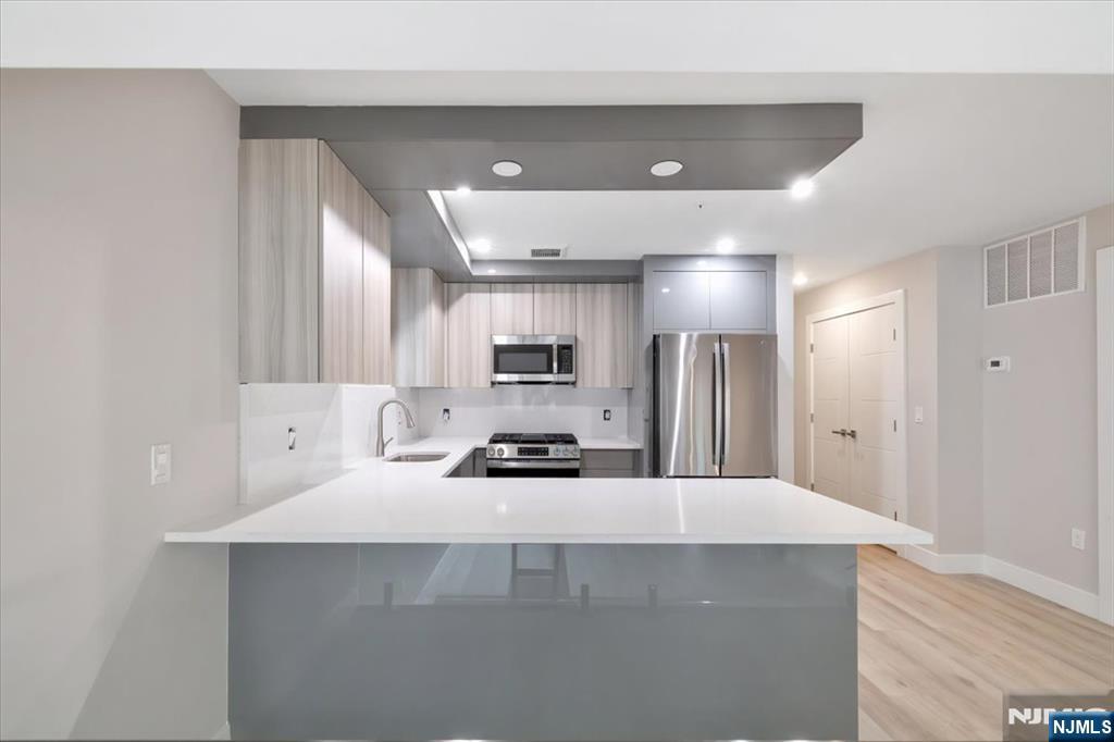 526 64th Street, Unit 3 West New York, NJ 07093 - Photo 5 of 19 a kitchen with a sink a counter top space stainless steel appliances and cabinets