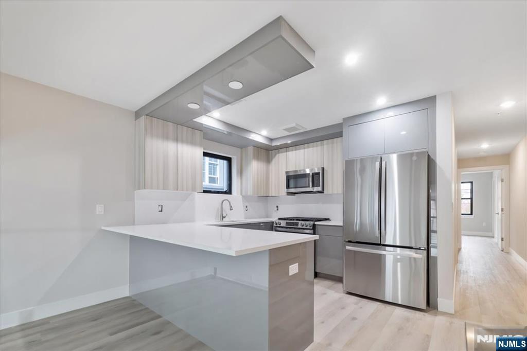 526 64th Street, Unit 3 West New York, NJ 07093 - Photo 6 of 19 a kitchen with kitchen island a refrigerator and a sink