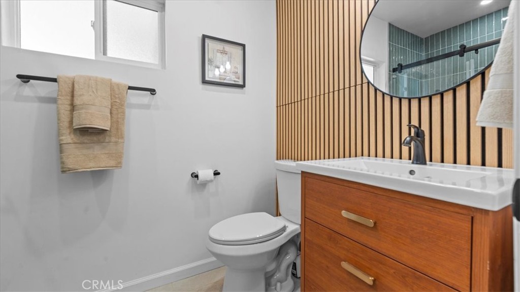 132 South Acacia Avenue Rialto, CA 92376 - Photo 11 of 23 a bathroom with a sink a toilet and a mirror