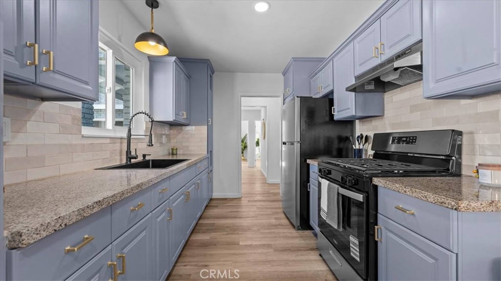 132 South Acacia Avenue Rialto, CA 92376 - Photo 8 of 23 a kitchen with stainless steel appliances granite countertop a sink a stove and a refrigerator